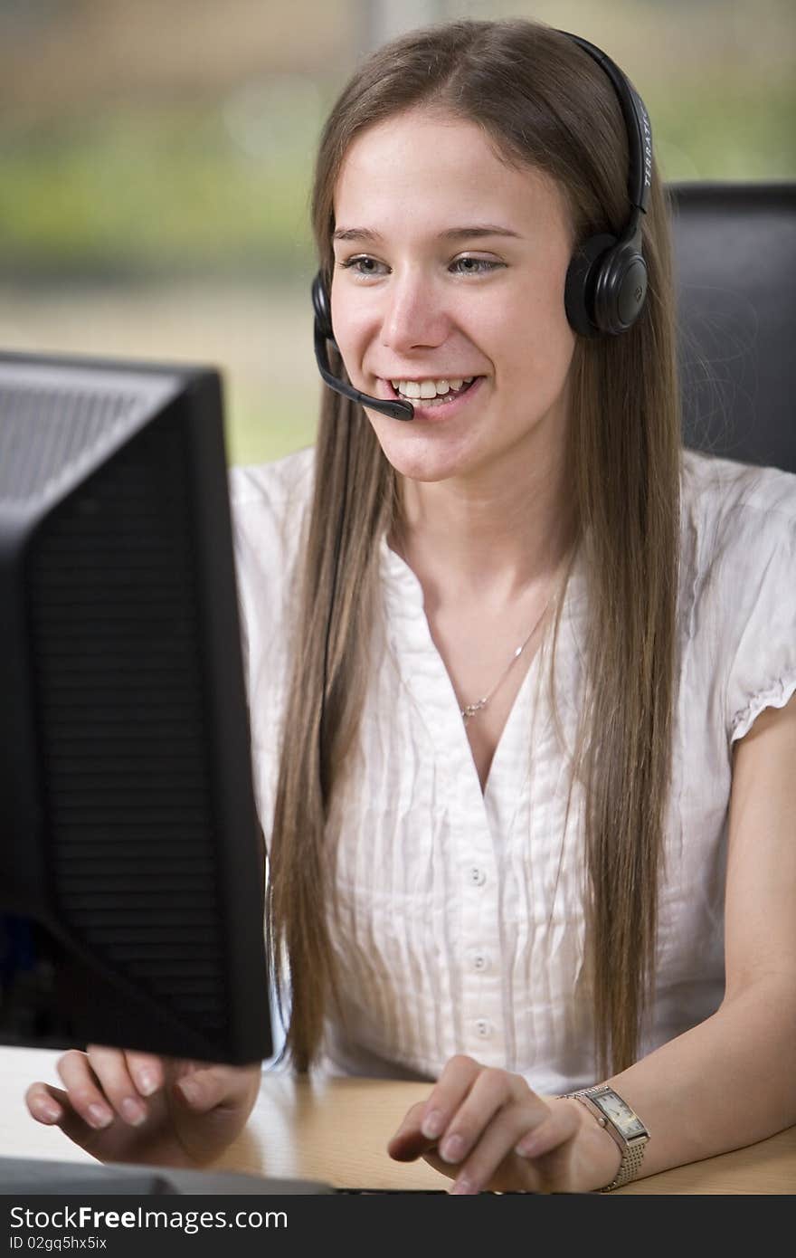 A female employee takes a call at her desk. A female employee takes a call at her desk.