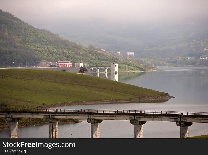 A blue sky with whit clouds and green field, dike , lake a  bridge. A blue sky with whit clouds and green field, dike , lake a  bridge