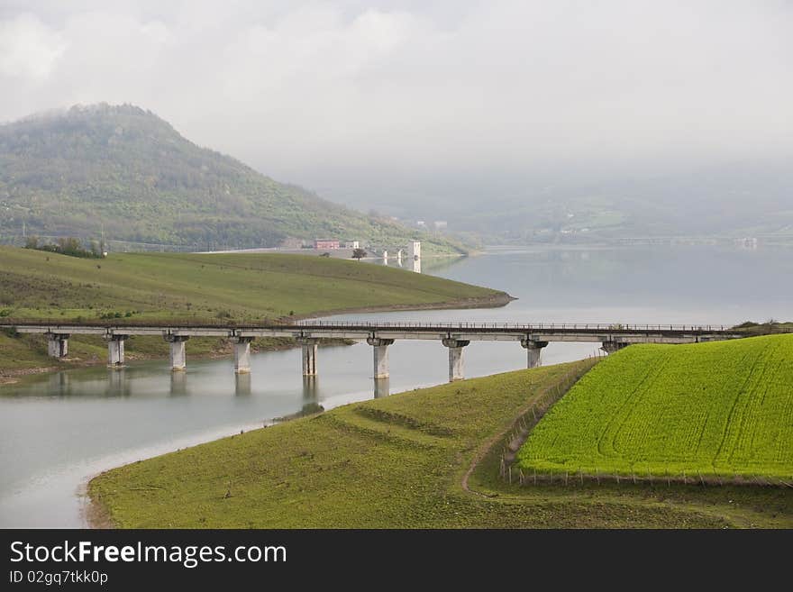 A blue sky with whit clouds and green field, , lake a bridge. A blue sky with whit clouds and green field, , lake a bridge