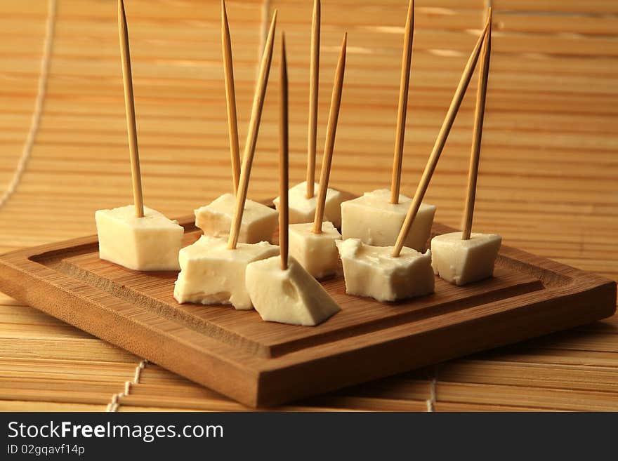 Pieces of white cheese on a wooden board. Pieces of white cheese on a wooden board