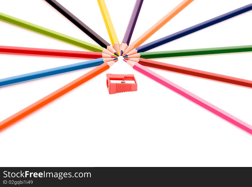 Close-up image of multicolor pencils and red sharpener isolated on white background