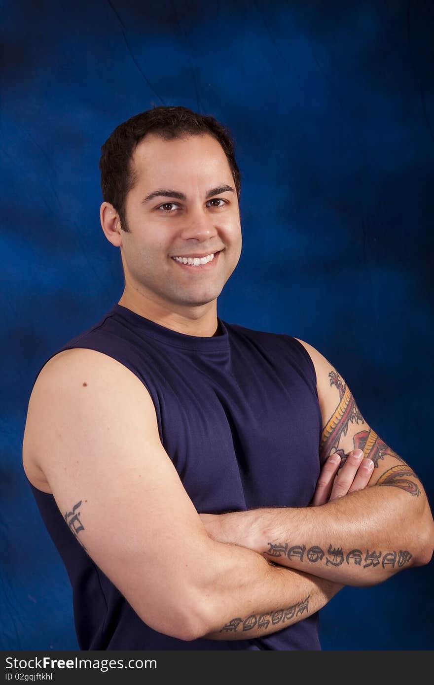 Handsome hispanic man with tattoos on his crossed arms. Handsome hispanic man with tattoos on his crossed arms.