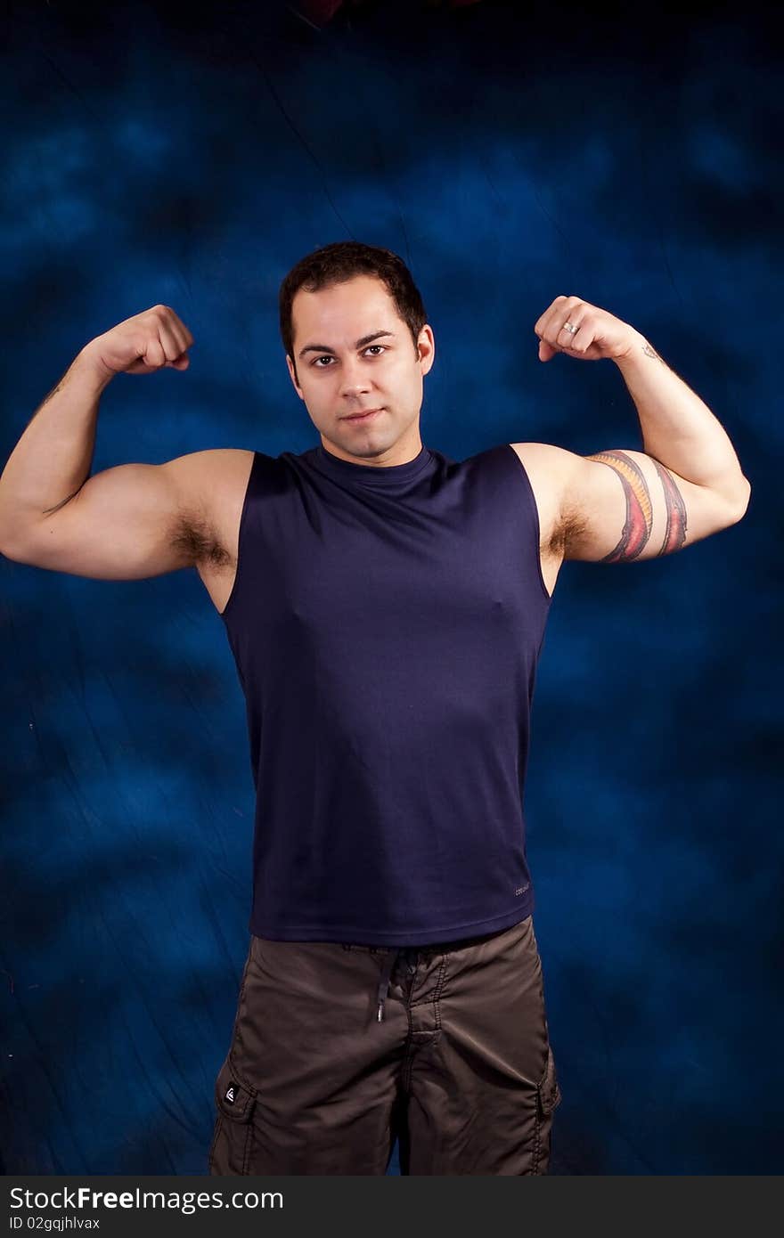 Hispanic man showing off his huge bicep mucles. Hispanic man showing off his huge bicep mucles.