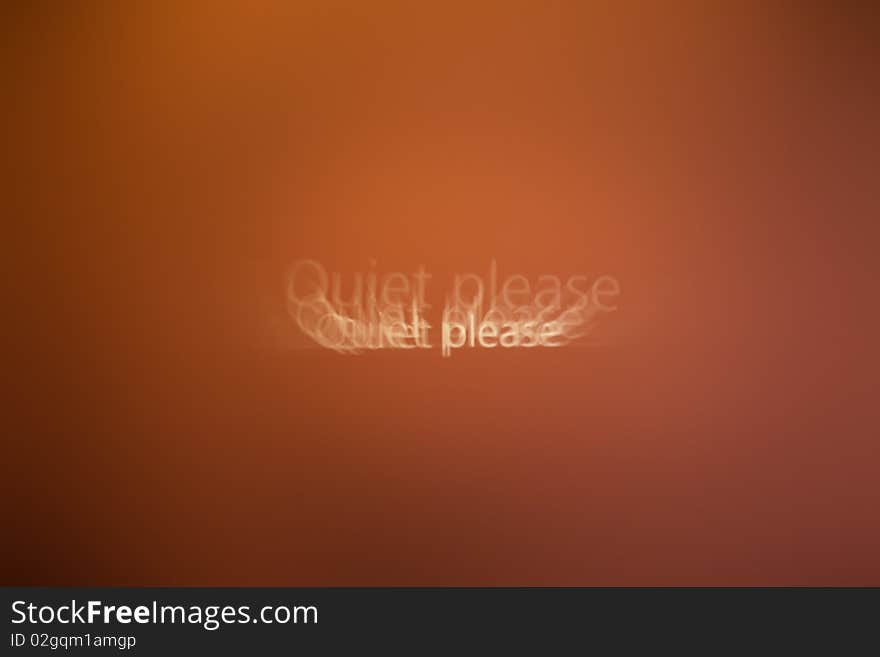 Blurred text Quiet please on a wall with warm red color