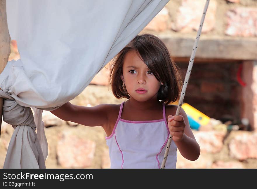 A young girl concentrated before playing on her homemade swing. A young girl concentrated before playing on her homemade swing