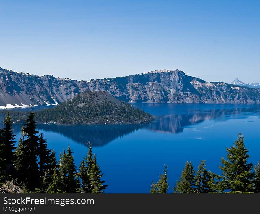 Crater Lake in Oregon with a perfect reflection on a calm sunny day. Crater Lake in Oregon with a perfect reflection on a calm sunny day