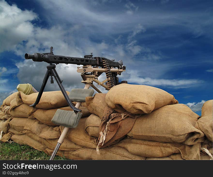 Machine gun on sand bags with threatening sky behind with clipping-path