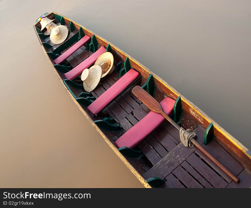 Empty boat floating on the calm river with only hats on it , closeup shot taken from above,SE Asia. Empty boat floating on the calm river with only hats on it , closeup shot taken from above,SE Asia