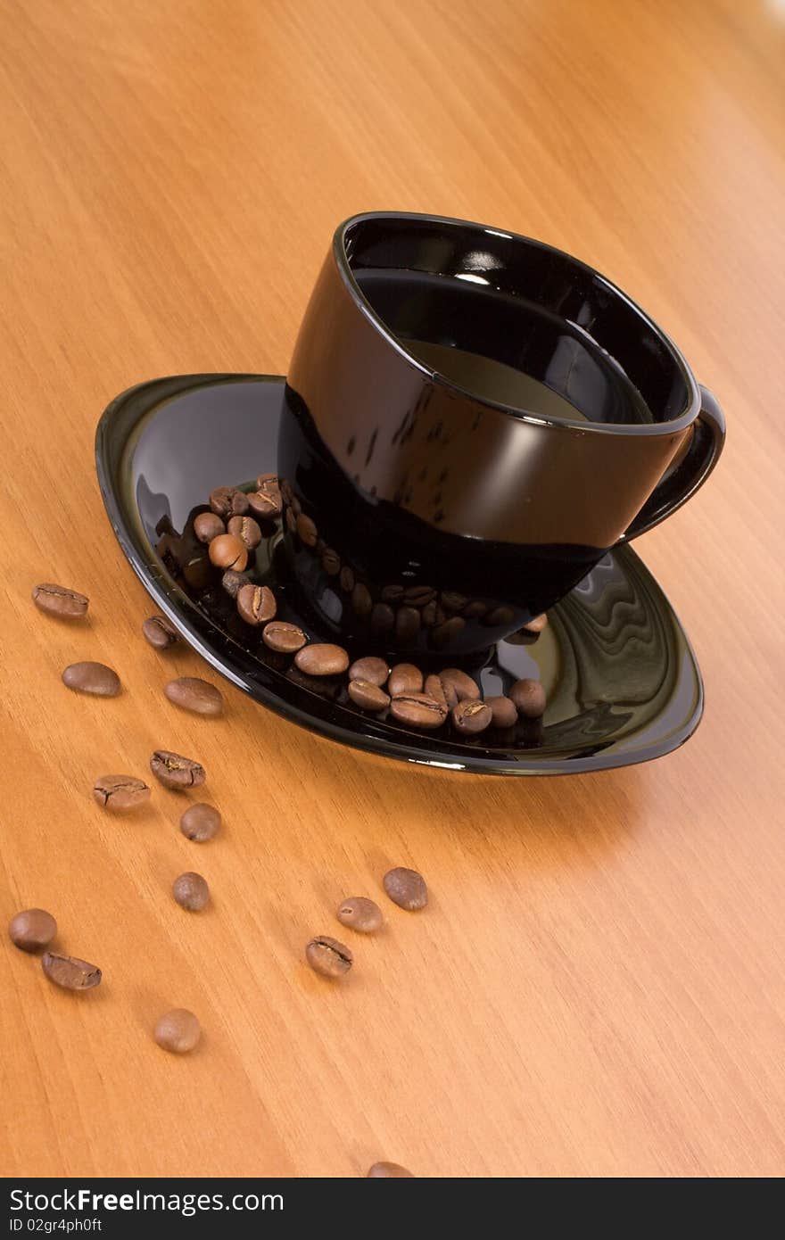 Mug with coffee and beans on the wood table