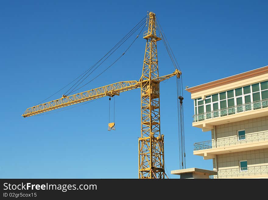 Construction crane against the blue sky. Day. Construction crane against the blue sky. Day.