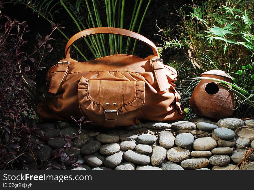 This is a beautiful ladies leather handbag isolated on a beautiful stony background.