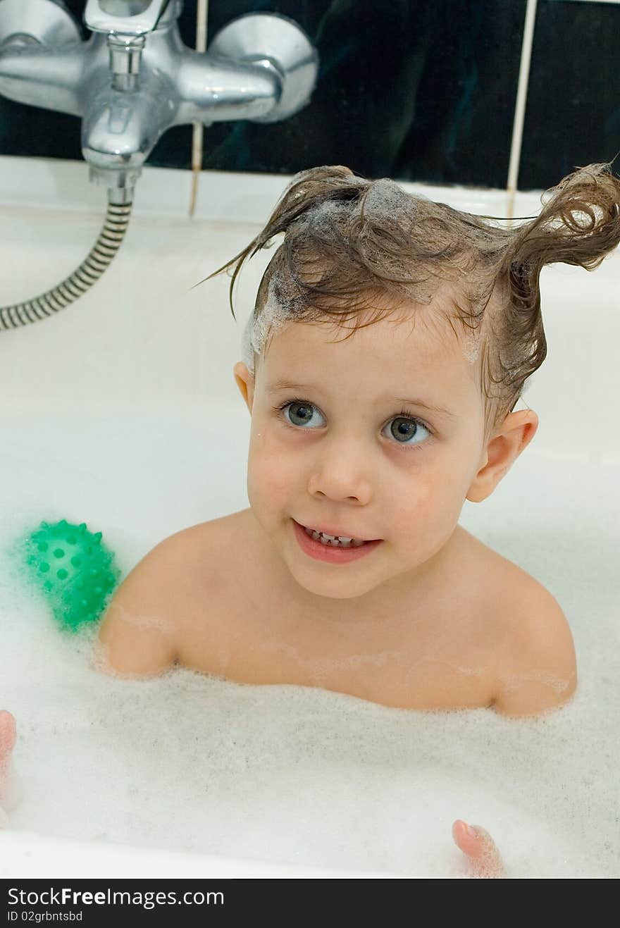 The girl with a soap head in a bath