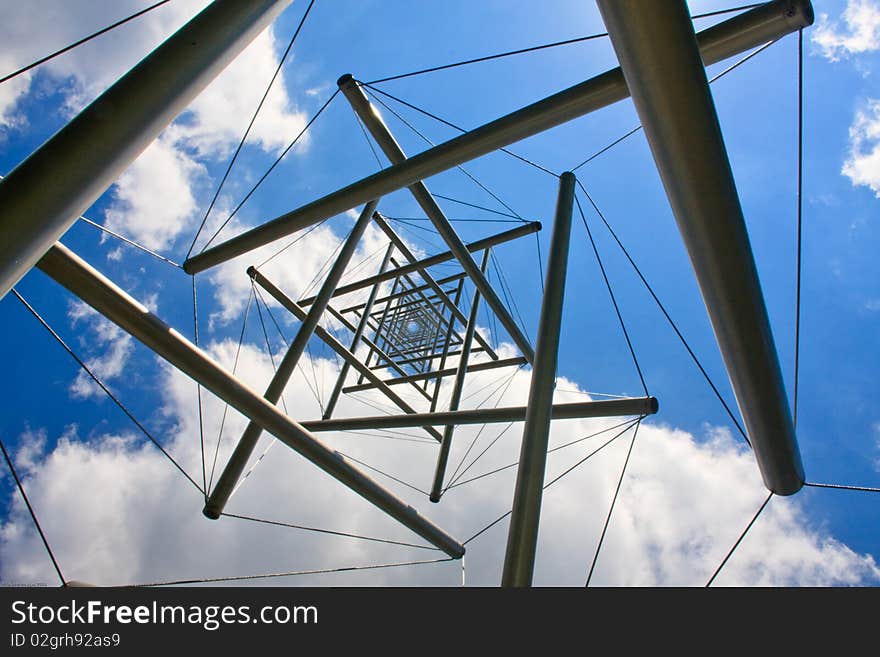 A stainless steel and cable tower structured photographer from below. A stainless steel and cable tower structured photographer from below