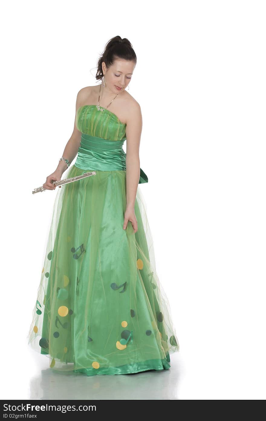 Attractive young female flautist, flutist holding flute. Evening green dress. Studio shot, white background.