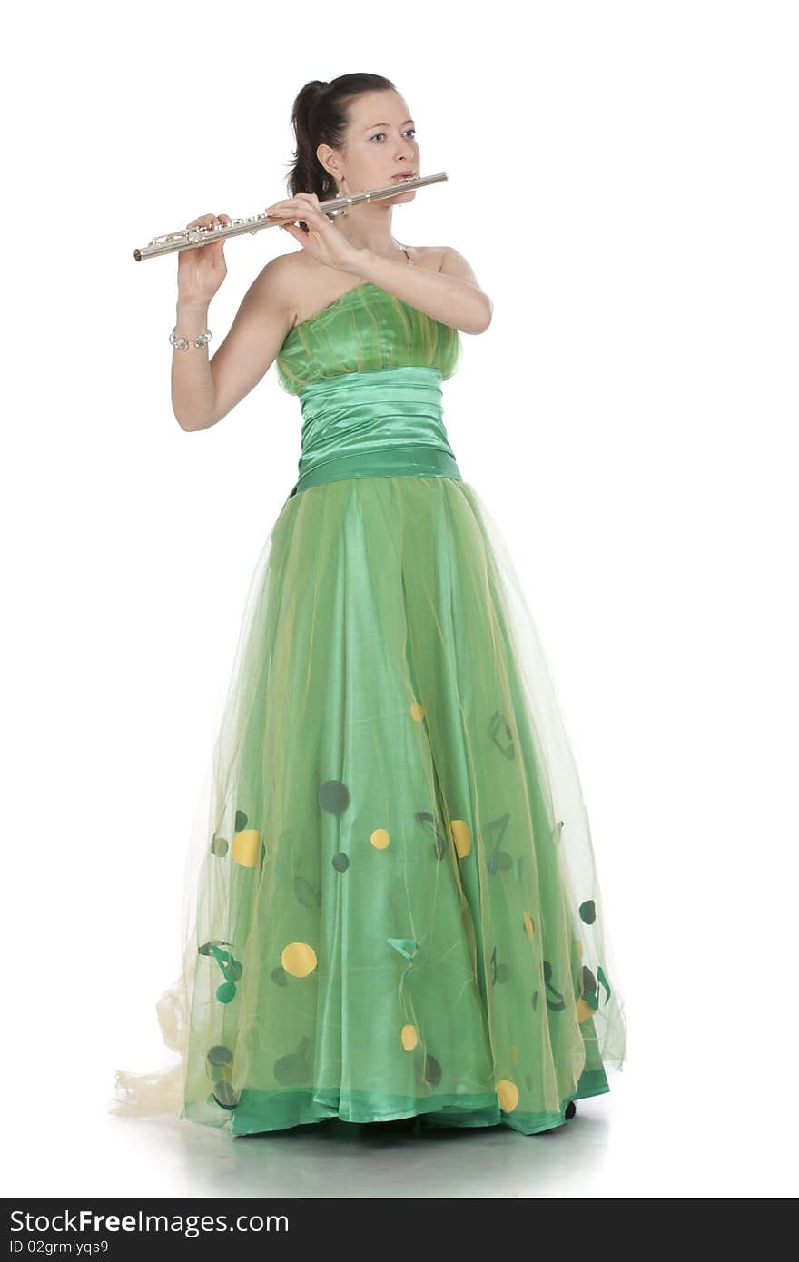 Attractive young female flautist, flutist holding flute. Evening green dress. Studio shot, white background.