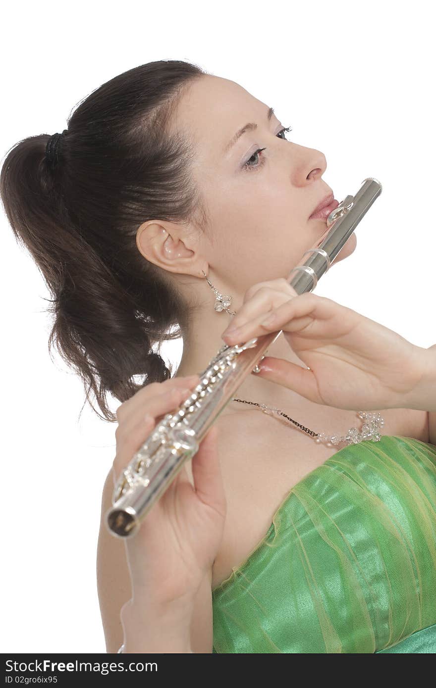 Attractive young female flautist, flutist holding flute. Evening green dress. Studio shot, white background.