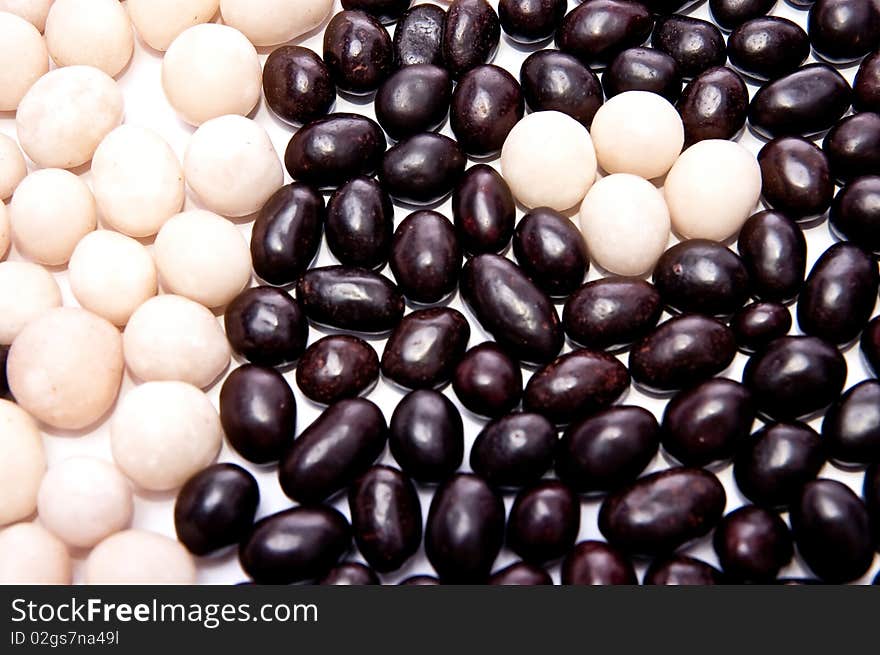 The nuts in black and white chocolate. White background. The nuts in black and white chocolate. White background