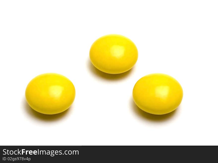 Yellow pills on white background