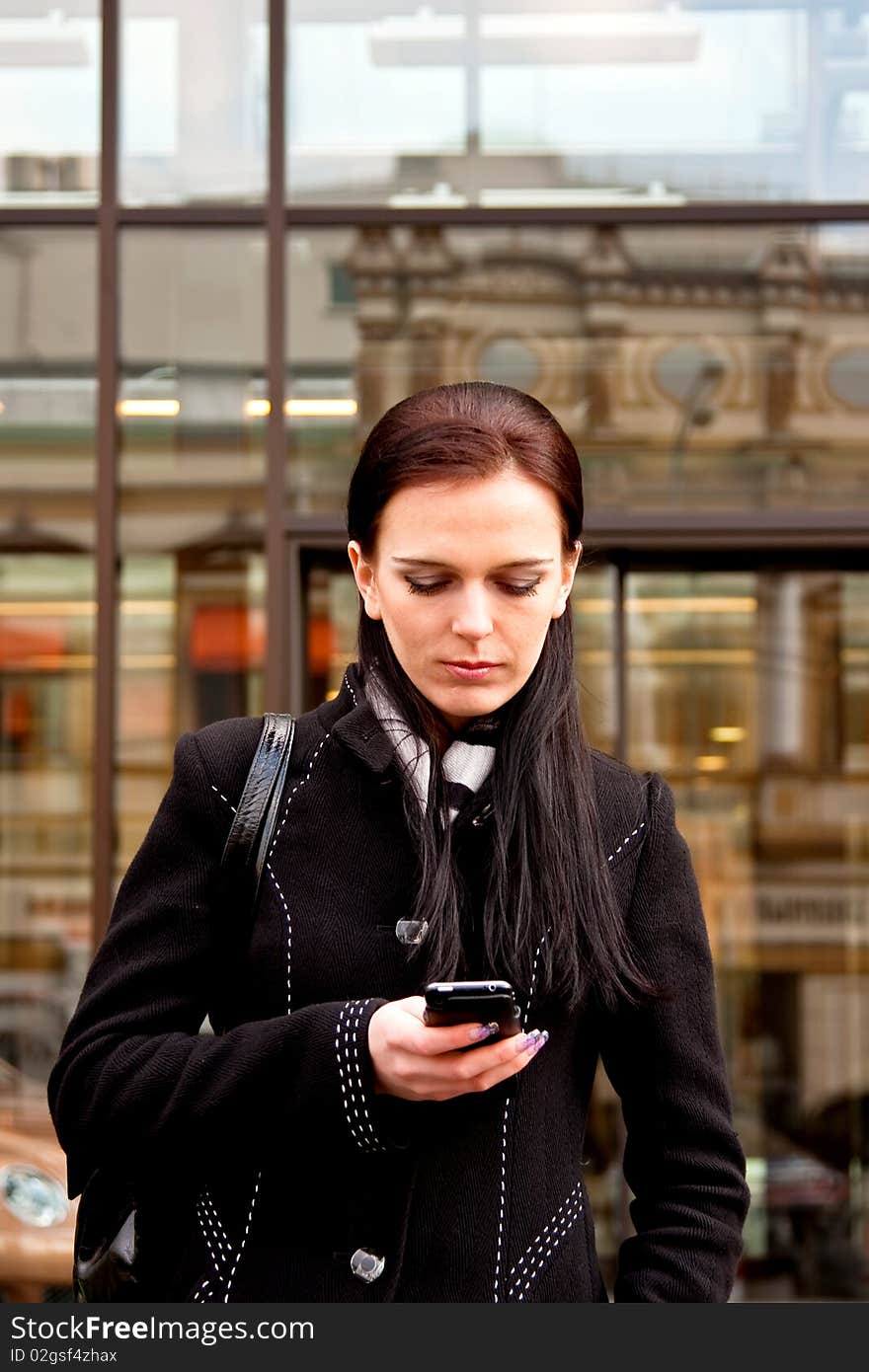 Business lady awaiting and writing sms