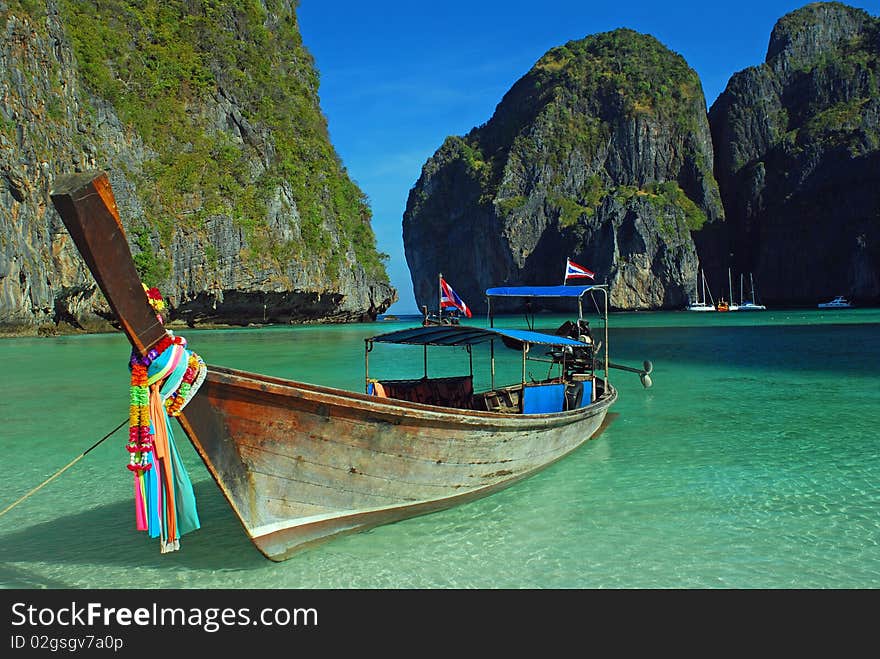 Longboat anchored at maya bay, thailand. Crystal clear waters, clear skies and perfect scenery. Longboat anchored at maya bay, thailand. Crystal clear waters, clear skies and perfect scenery.