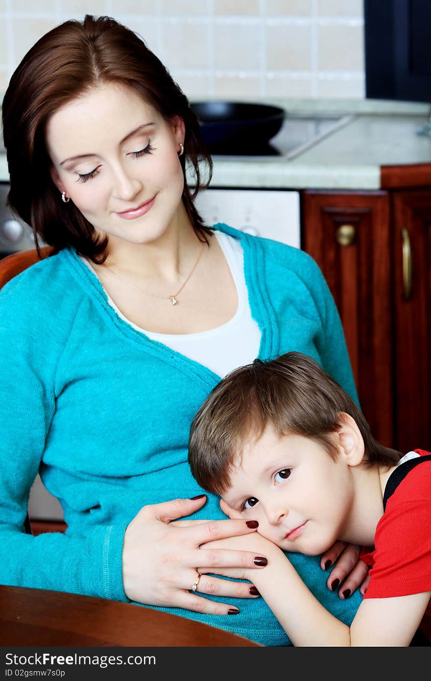 Happy pregnant woman with her son at home. Happy pregnant woman with her son at home.