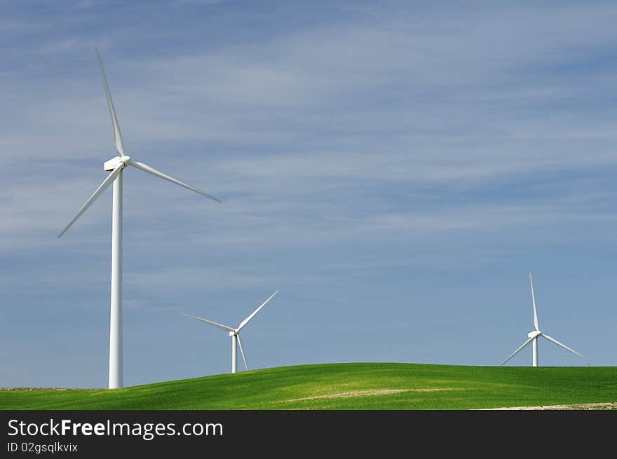 Windmills in a green meadow with cloudy sky. Windmills in a green meadow with cloudy sky