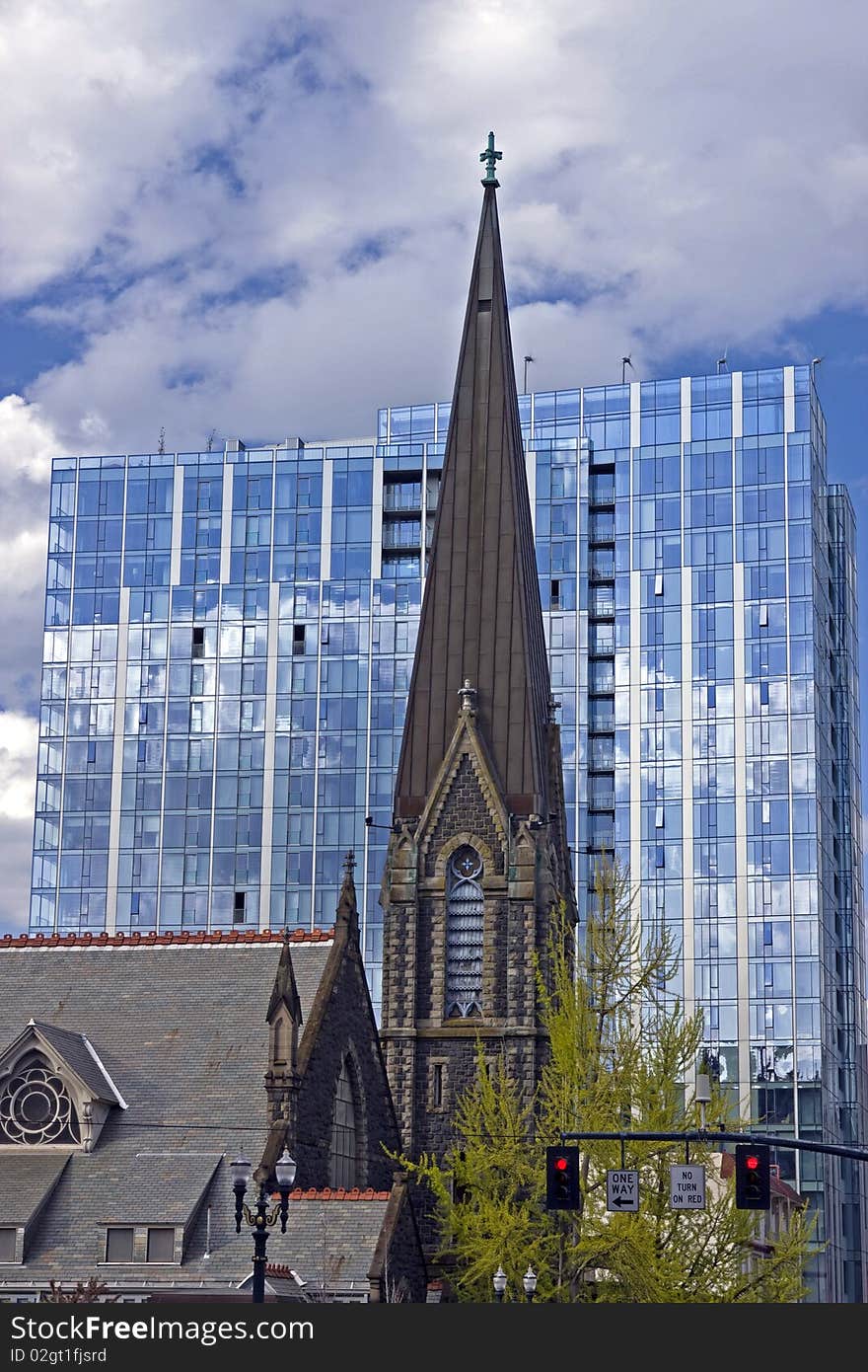 Modern verses old with old church standing in front of modern windowed building in Portland Oregon. Modern verses old with old church standing in front of modern windowed building in Portland Oregon