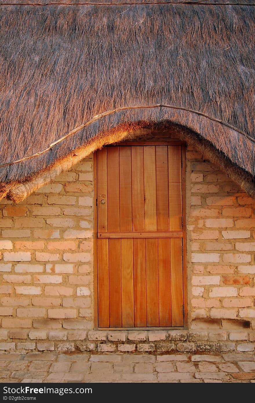 Wood door and thatched roof of a home in Tanzania. Wood door and thatched roof of a home in Tanzania