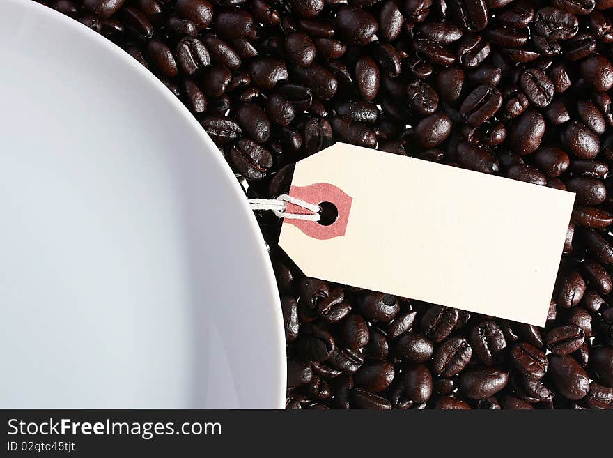 On coffee grains a white plate and a label for an inscription.