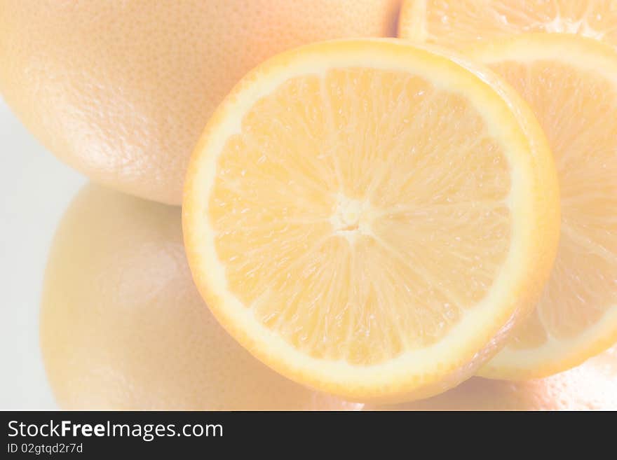 Light, yellow background - an oranges, one orange cut asunder, close-up. Light, yellow background - an oranges, one orange cut asunder, close-up.