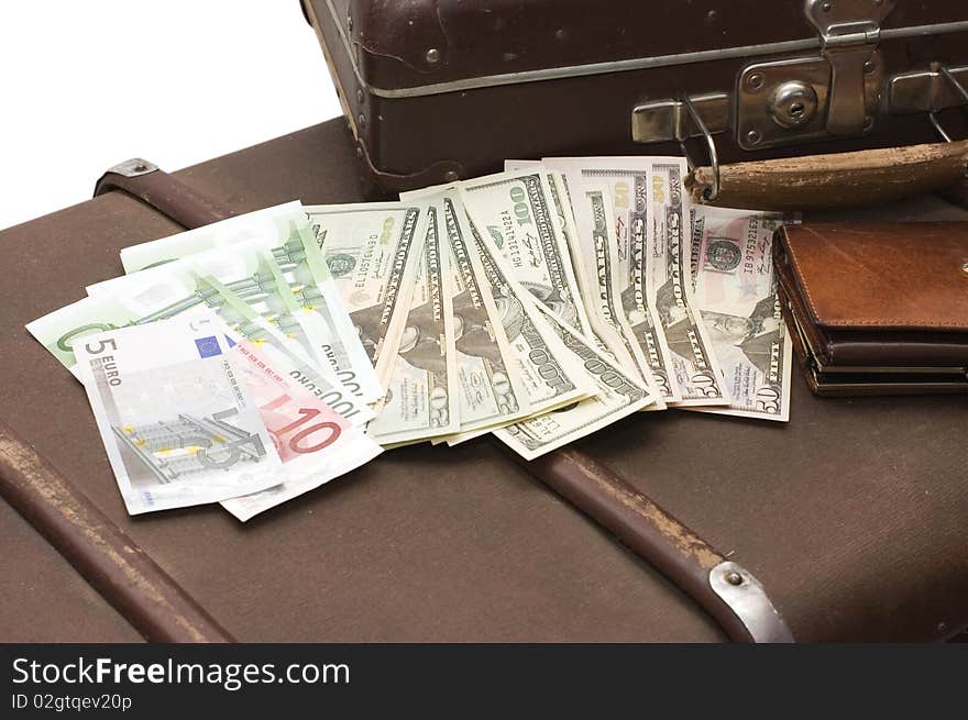 Money lays on an old suitcase