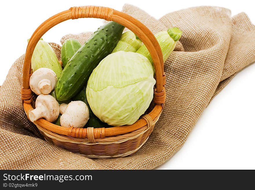 Wattled basket with vegetables isolated on white