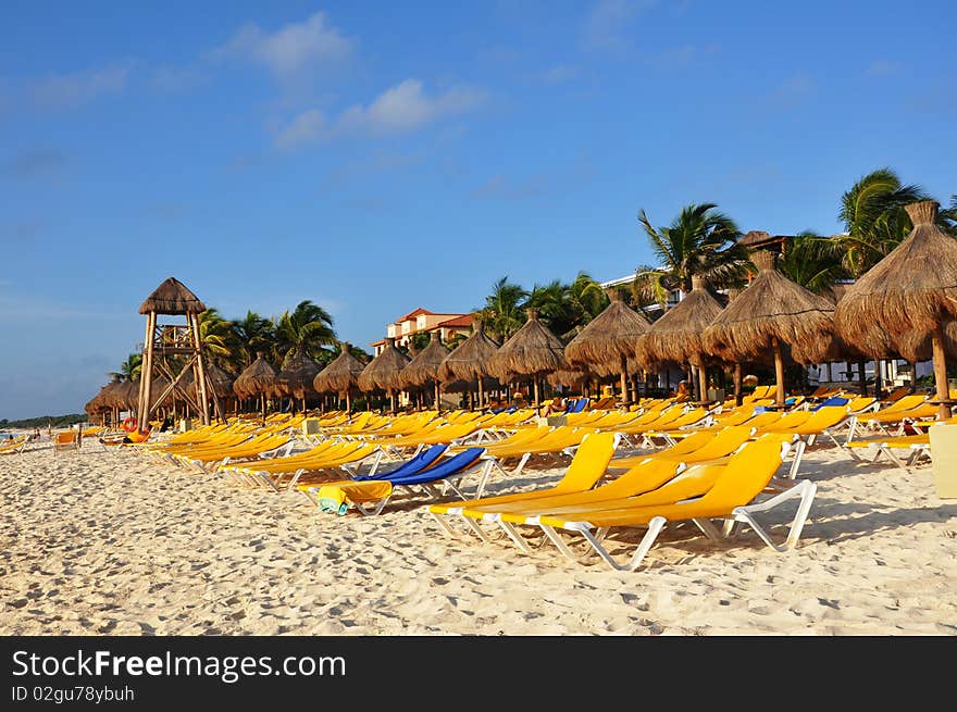 Sand, empty yellow plank beds, grassy umbrellas and the sea. Sand, empty yellow plank beds, grassy umbrellas and the sea.