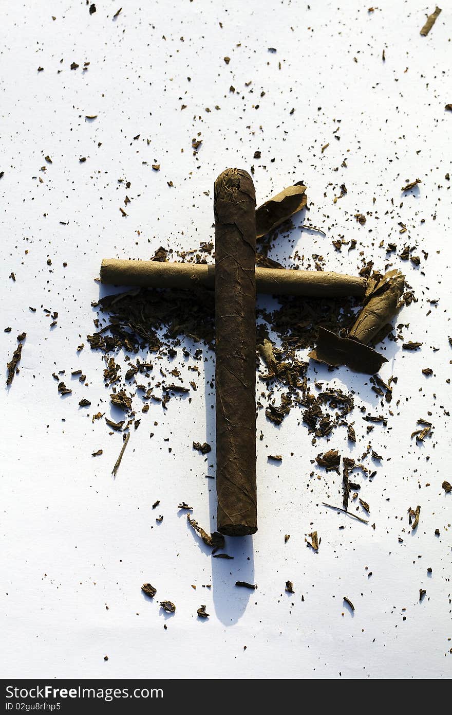 Cross from cigars with the tobacco scattered around. Cross from cigars with the tobacco scattered around