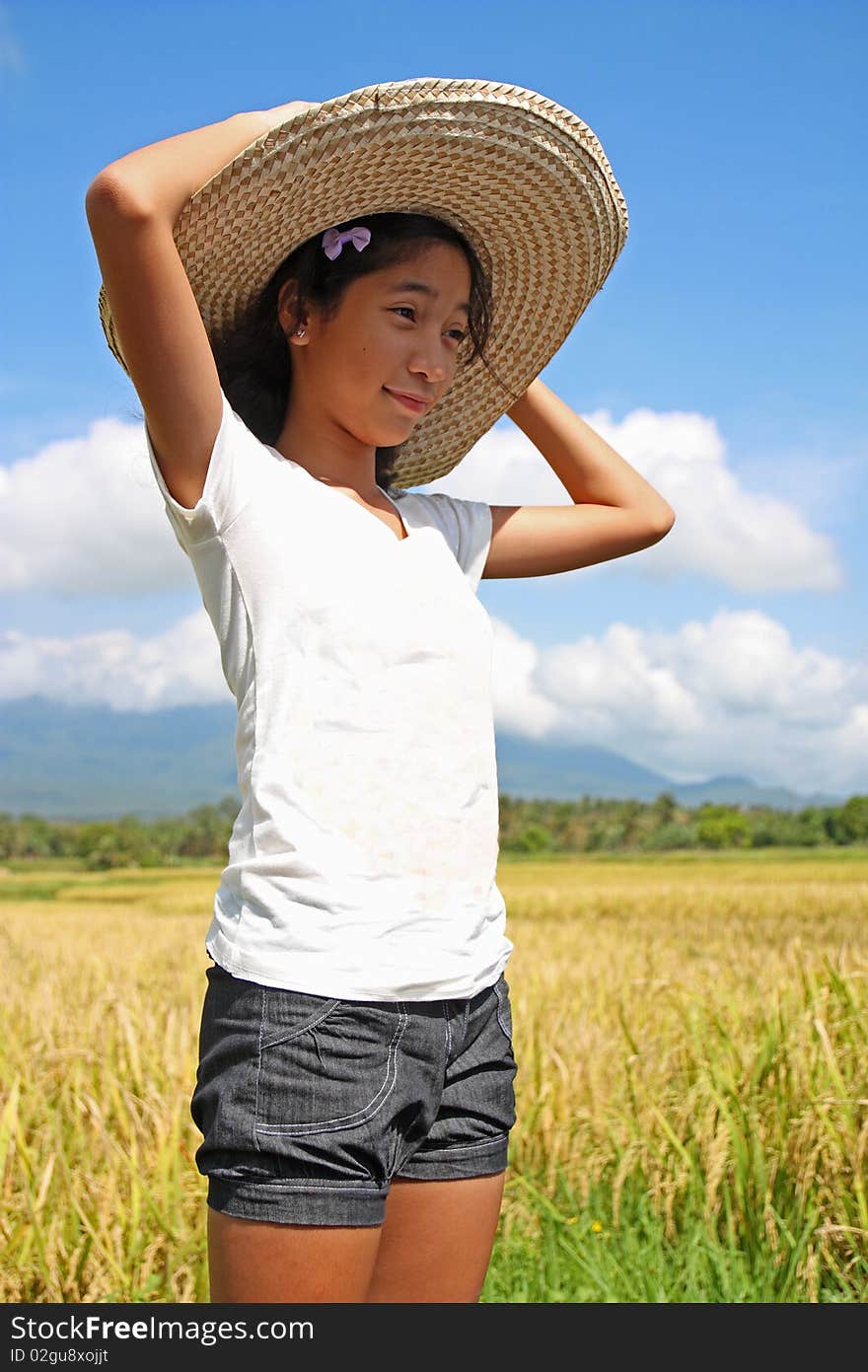 Happy girl standing beside a rice field. Happy girl standing beside a rice field