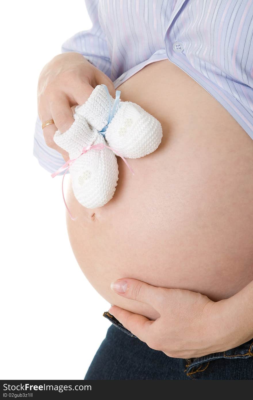 The pregnant woman with children's shoes. The pregnant woman with children's shoes