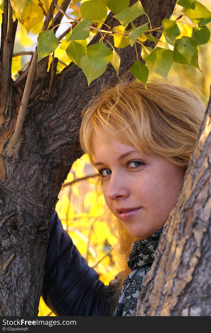 Girl in foliage in citys park.Foliage is green and yelloy. Girl in foliage in citys park.Foliage is green and yelloy