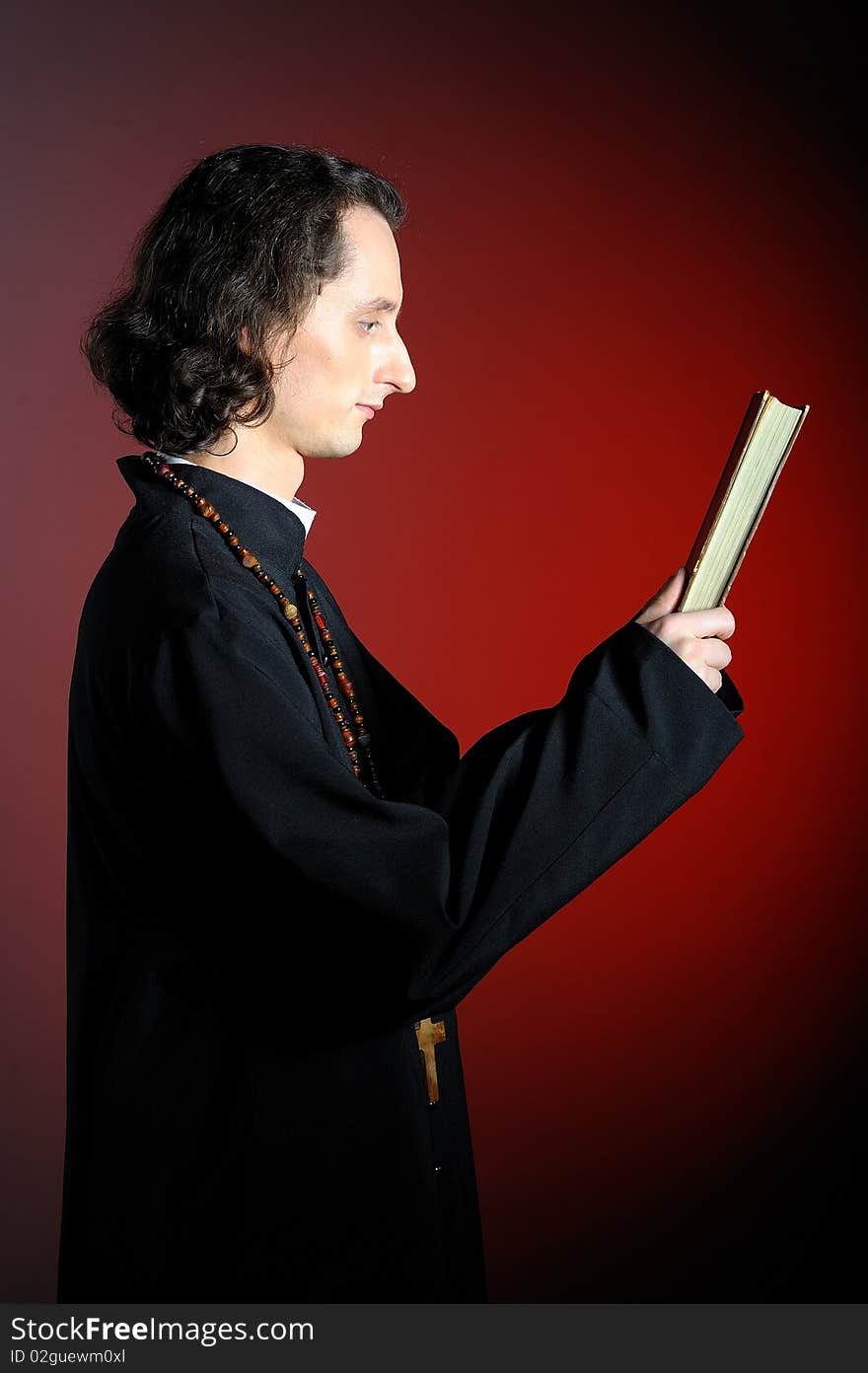 Conceptual portrait of Praying priest with bible