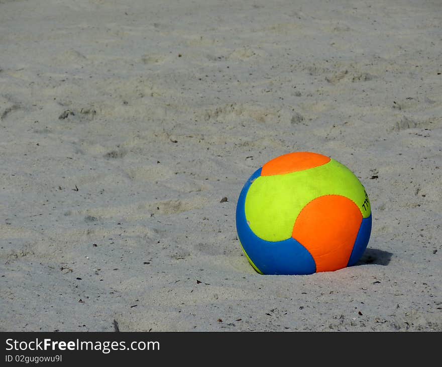 Orange, yellow and blue ball on beach sand. Orange, yellow and blue ball on beach sand
