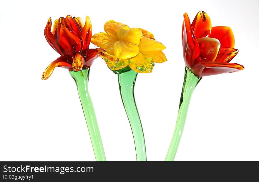 Flowers of colored glass (souvenir) closeup isolated on white.