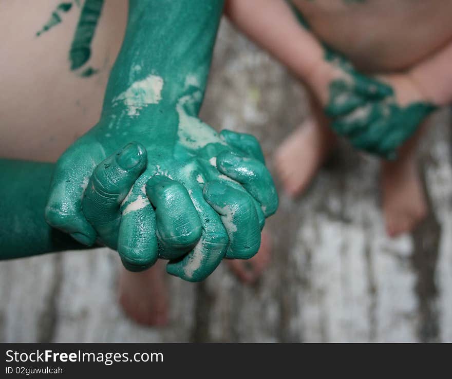 The hands of two children who have been playing with green paint. The hands of two children who have been playing with green paint