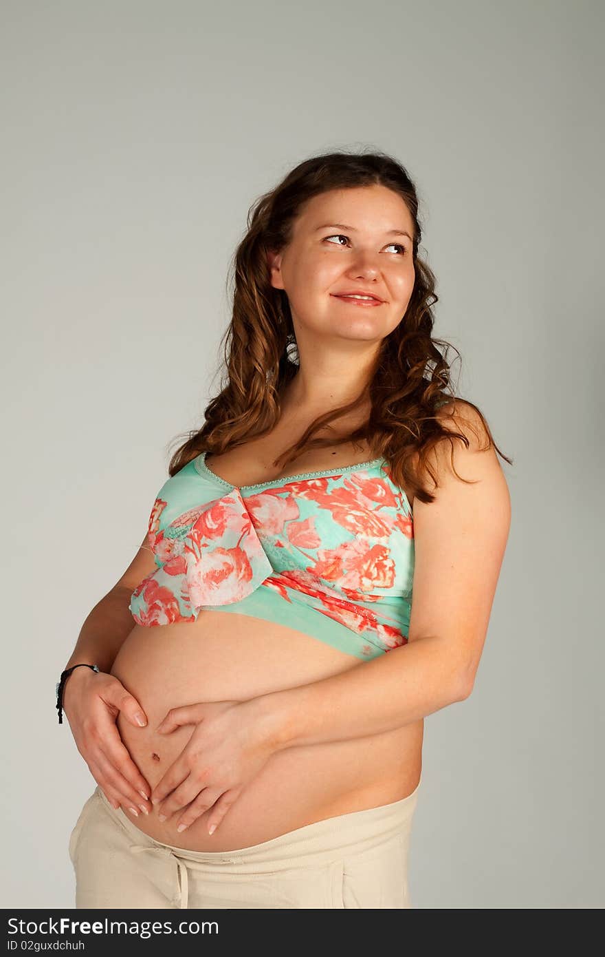 Pregnant beautiful woman making a heart shape on her stomach with her fingers. Pregnant beautiful woman making a heart shape on her stomach with her fingers.