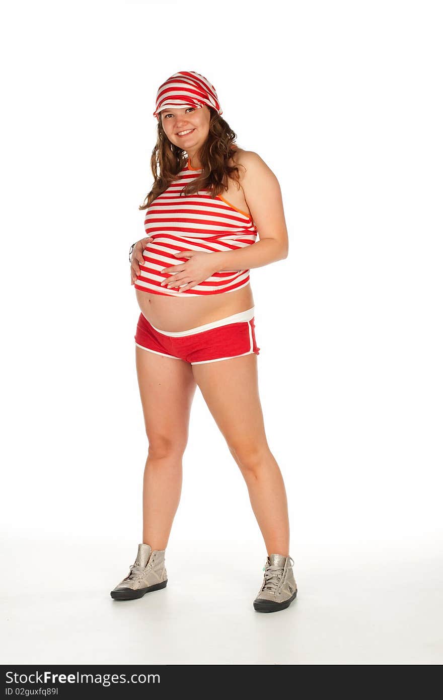 Pregnant beautiful smiling woman in a striped shirt and cap in red and white stripes holding hands on her belly. Pregnant beautiful smiling woman in a striped shirt and cap in red and white stripes holding hands on her belly.