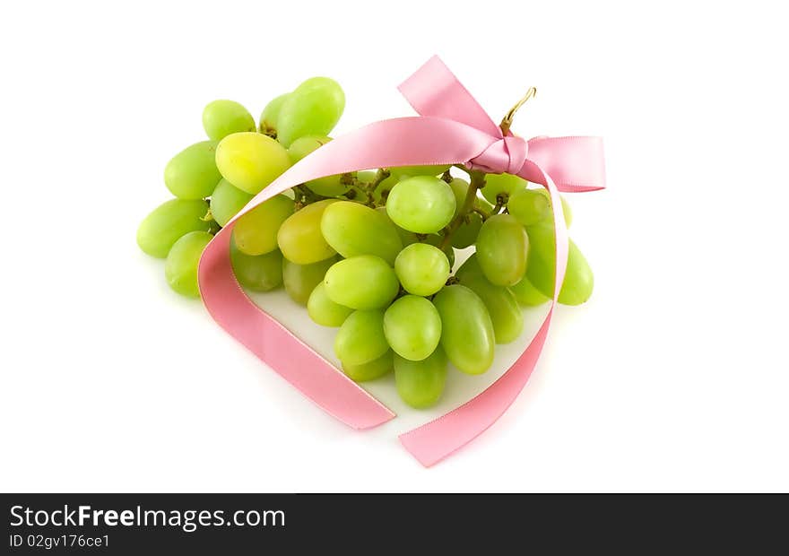 Grapes with a pink bow on white background