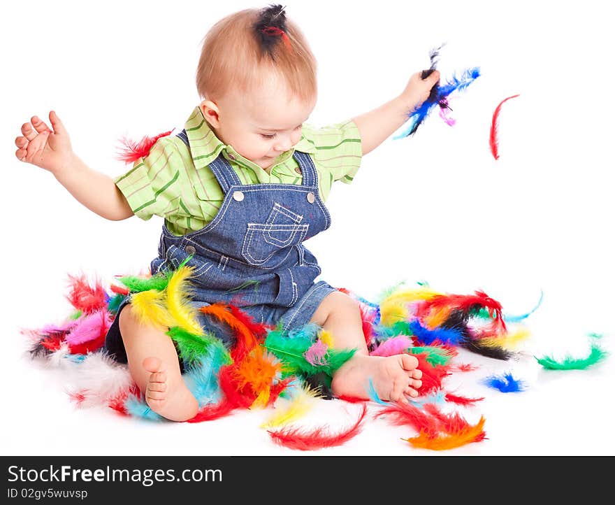 Little boy is sitting on a flow with feathers