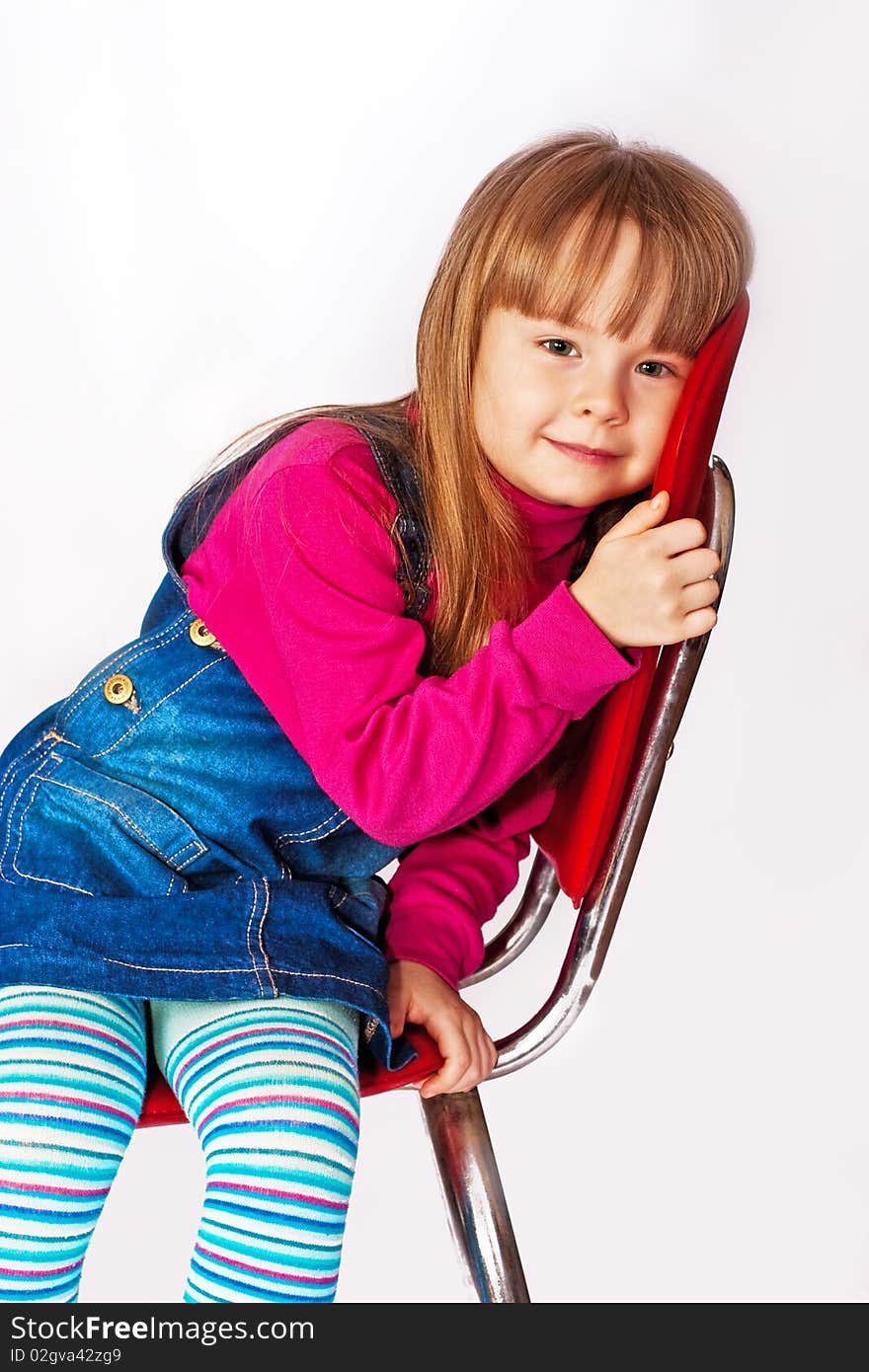 Portrait of the little girl sitting on a chair