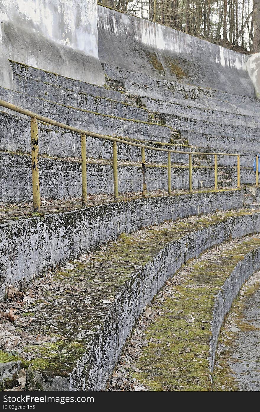 Old city sports stadium, the tribunes moss-grown and filled up by last year's leaves. Old city sports stadium, the tribunes moss-grown and filled up by last year's leaves