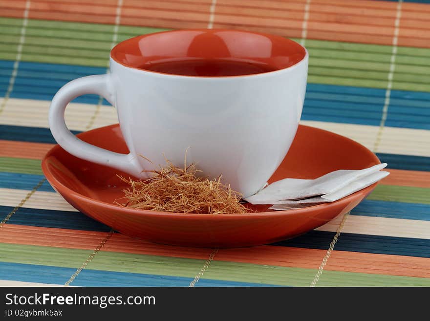 Cup of tea with teabag and sugar.