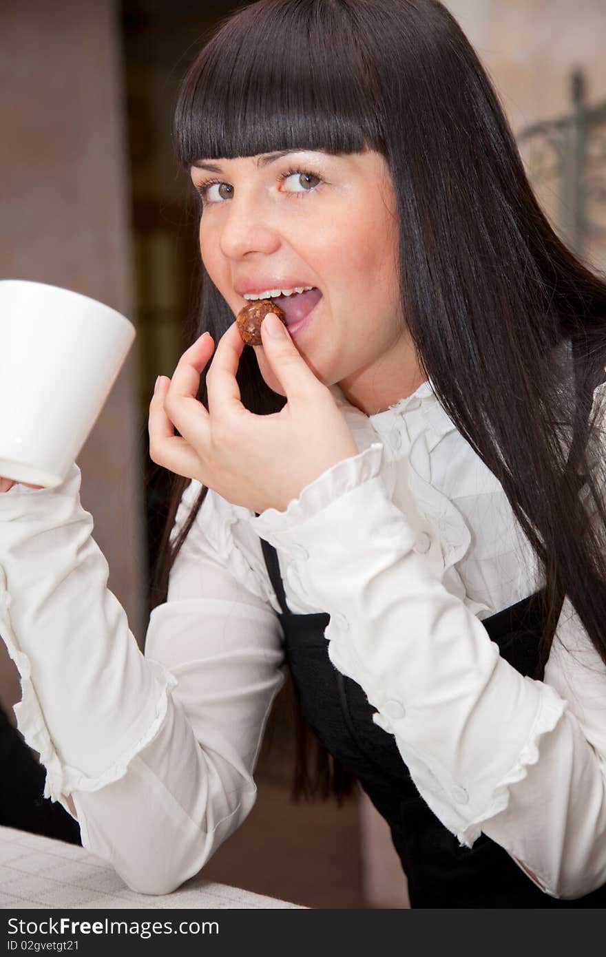 Young brunet girl in cafe is drinking coffee. Young brunet girl in cafe is drinking coffee