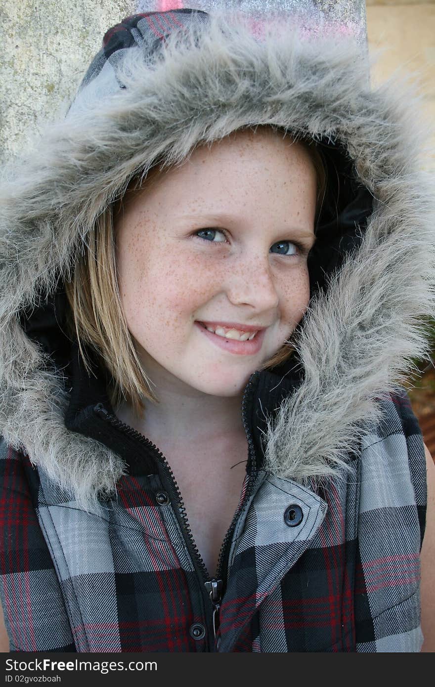 A cute white, caucasian girl child with a winter jacket, keeping warm. A cute white, caucasian girl child with a winter jacket, keeping warm